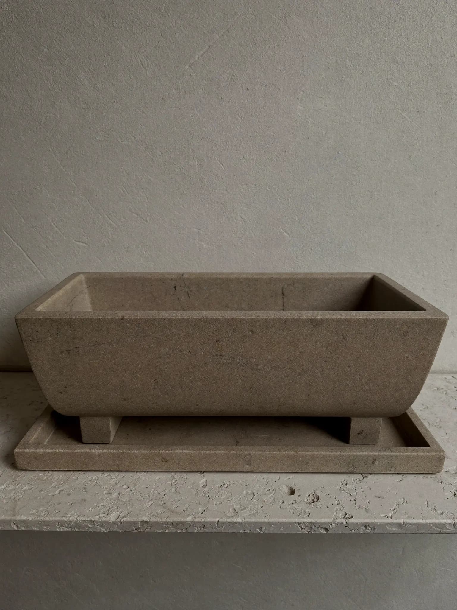 Herb Trough stoneware planter in oat matte glaze, on a stone block against a plaster wall